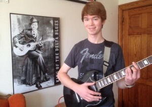 Colton, practicing in front of his Robert Johnson poster.