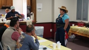 Sandi Hache, dressed as a farmer, explaining the rules for the chili cook-off.