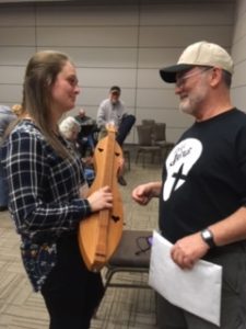 Joe Collins is giving Sydney Hardin, a student at Gardner-Webb University, tips on playing the dulcimer.